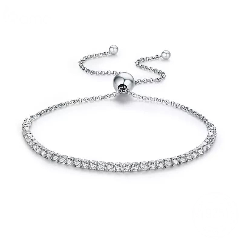 A silver tennis bracelet with pavé setting zirconia crystals, featuring a sliding closure.